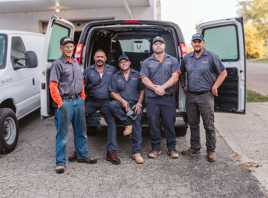 Professional plumbing service team beside a work van